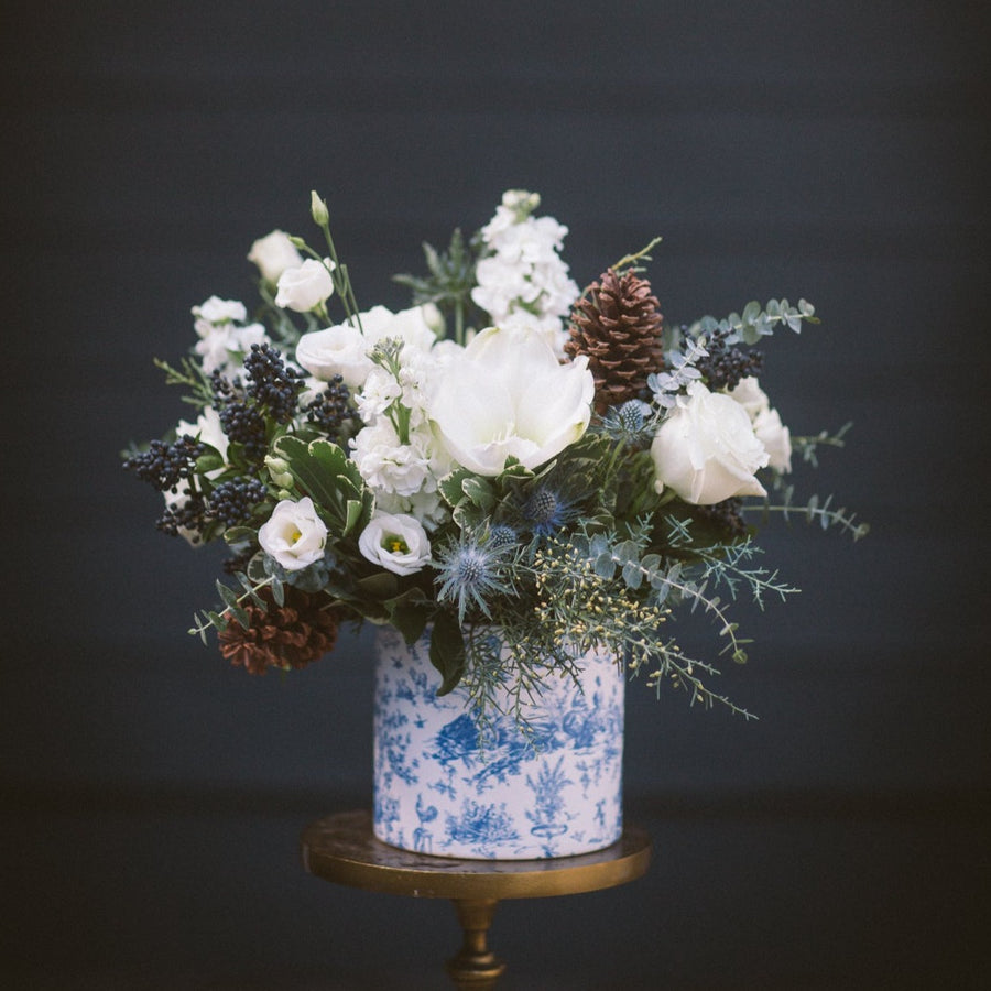 Large toile winter pot with all white and green florals and winter greens and cones.
