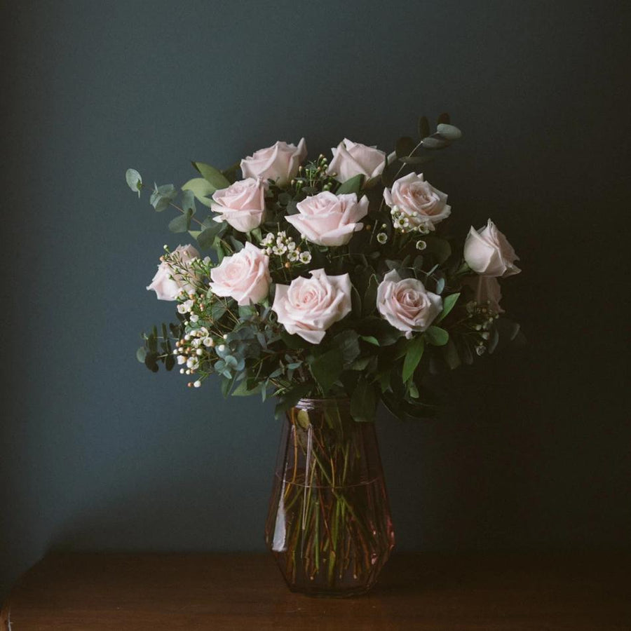 One dozen pink roses in vase