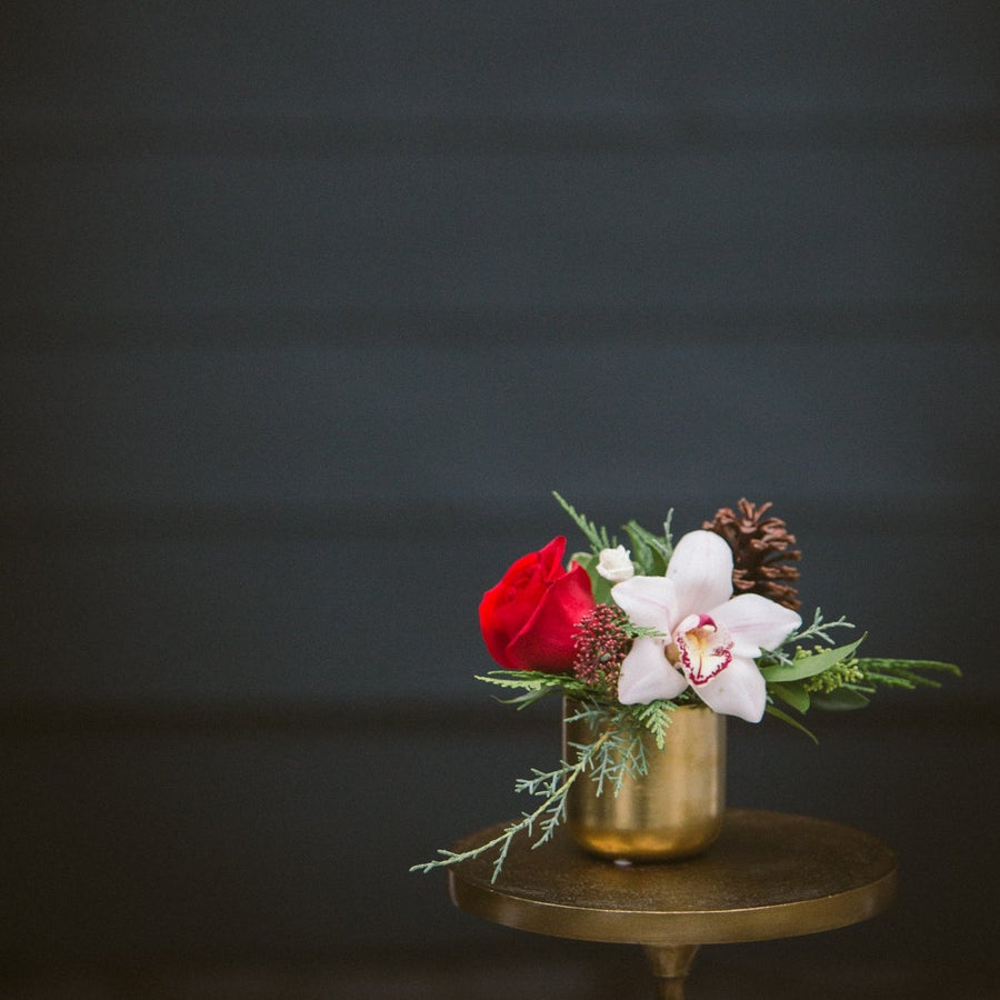 tiny gold vase with orchid, rose and pine cone